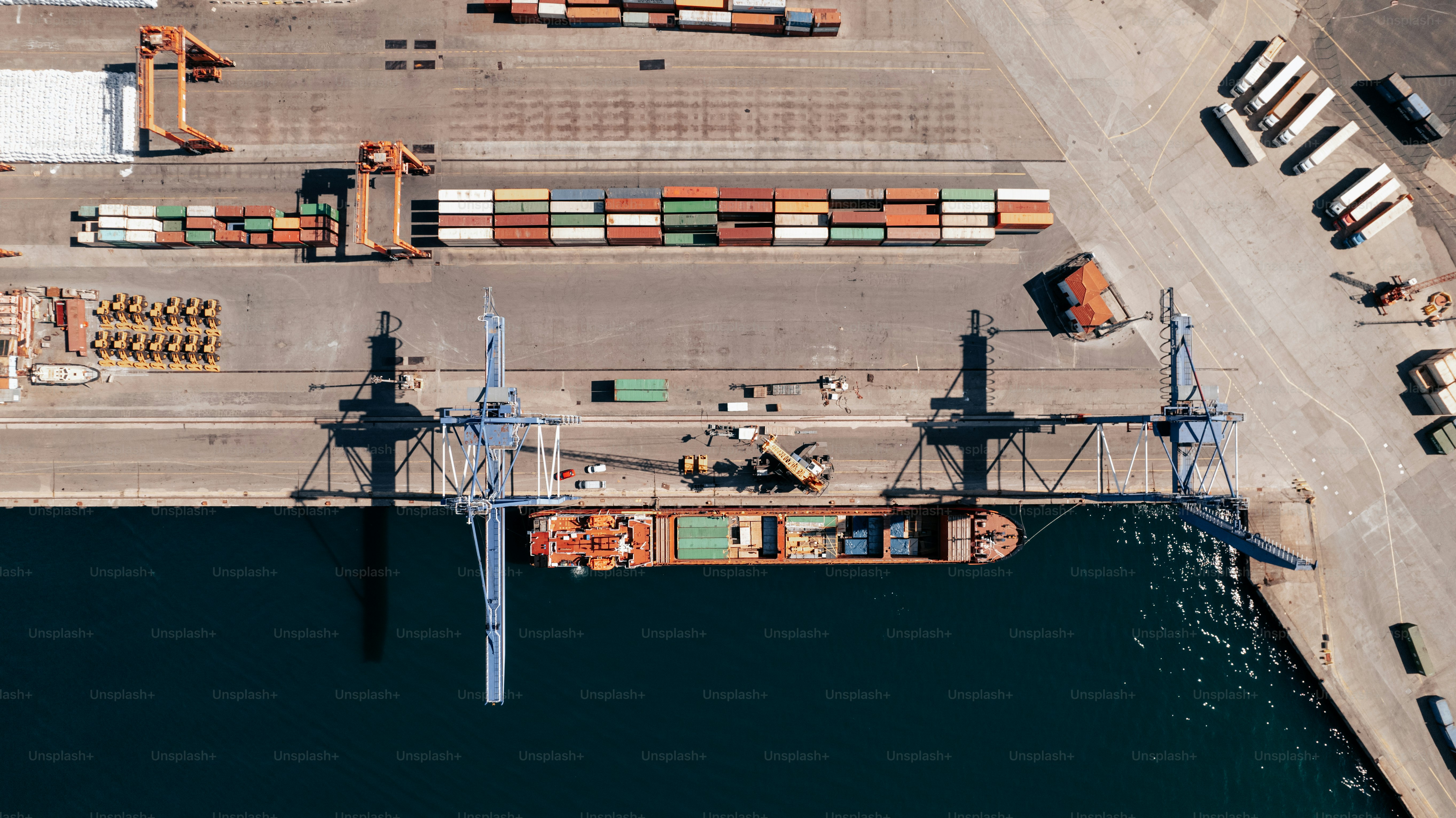 an aerial view of a cargo ship docked at a dock